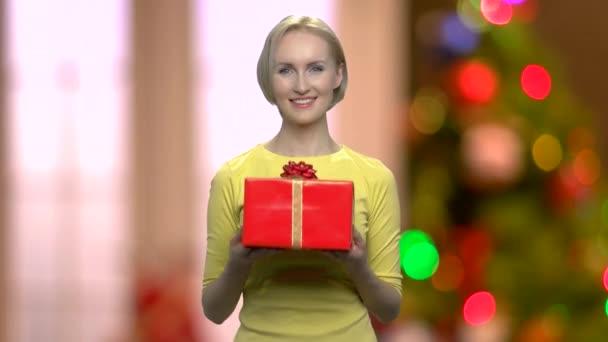 Mujer dando caja de regalo en fondo abstracto de Navidad . — Vídeos de Stock