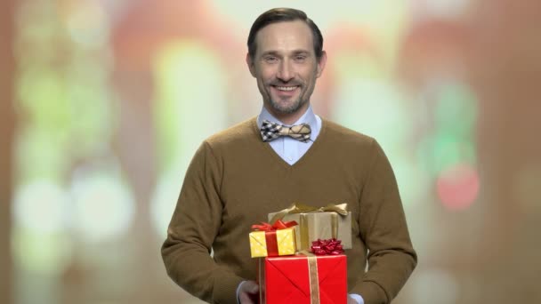 Homme souriant donnant des boîtes-cadeaux . — Video