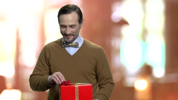 Schöner Mann zeigt festliche Geschenkschachtel. — Stockvideo