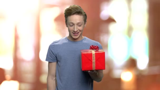 Porträt eines Teenagers, der eine Geschenkbox anbietet. — Stockvideo