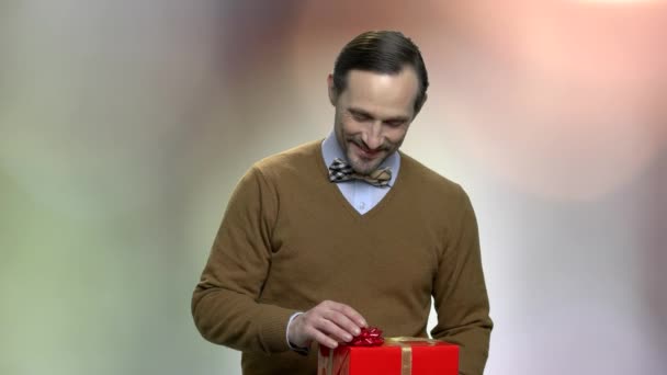 Улыбающийся кавказский мужчина дарит подарочную коробку . — стоковое видео