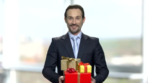 Atractivo empresario sosteniendo un montón de cajas de regalo . — Vídeos de Stock