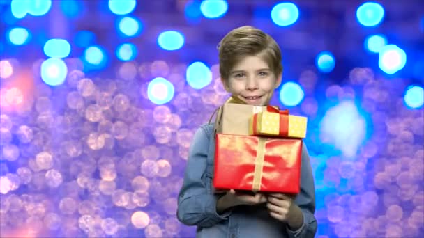 Ευτυχισμένο παιδί που κρατά κουτιά δώρων Χριστουγέννων. — Αρχείο Βίντεο