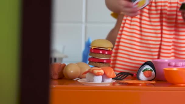 Nahaufnahme Kinder spielen mit Plastikgeschirr im Spielzimmer. — Stockvideo