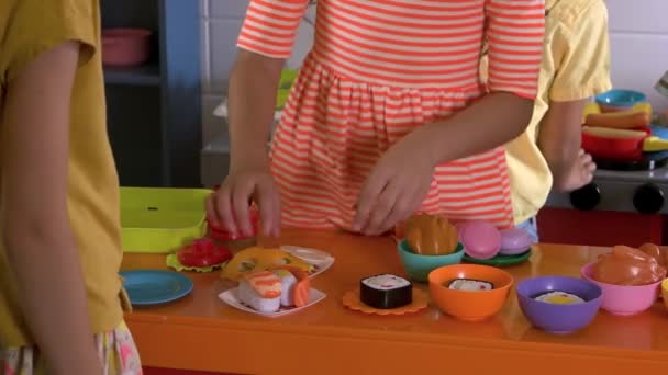 Close-up kinderen koken sushi met Toy Kitchen. — Stockvideo