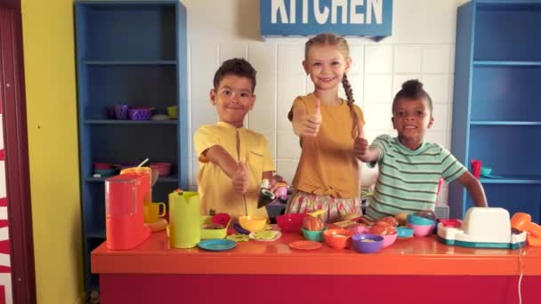 Cheerful kids showing thumbs up in entertainment center. — Stock Video