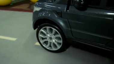 Eğlence odasında mini araba sürüş çocuk yakın.
