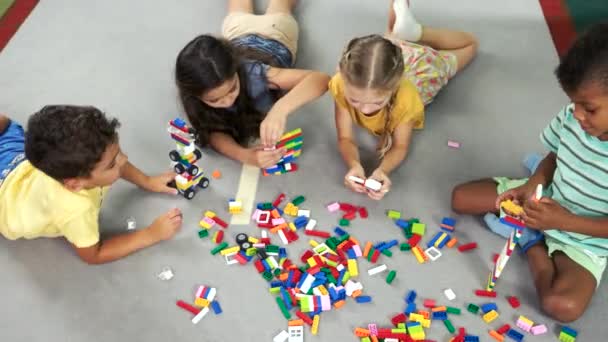 Niños en edad preescolar jugando con juguetes en el suelo . — Vídeo de stock