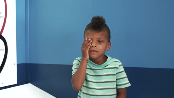 Médico oftalmólogo comprueba la visión de niño niño . — Vídeo de stock