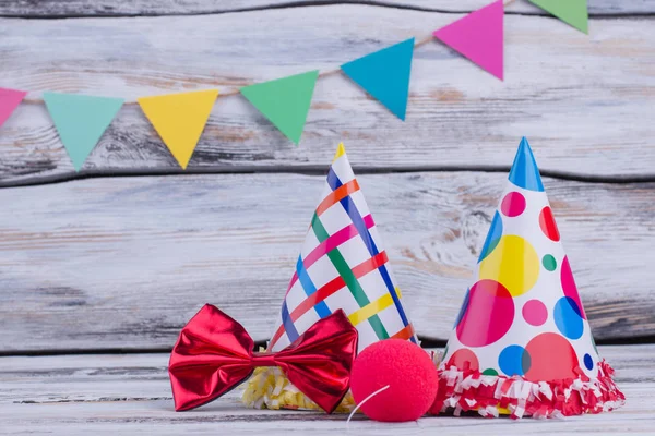 Party hats and other stuff on wooden background.