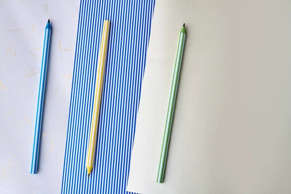 Три карандаша на бумажном фоне . — стоковое фото