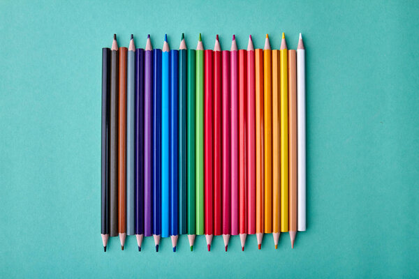 Ряд разноцветных карандашей на цветном фоне
.