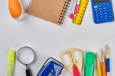 Beyaz arka planda dizüstü bilgisayar ve ofis malzemeleri.