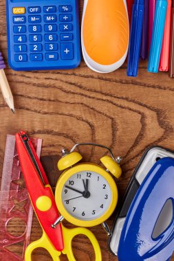 Ahşap arka plan üzerinde okul veya ofis malzemeleri.