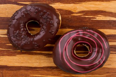 Ahşap arka plan üzerinde iki çikolatalı çörekler.