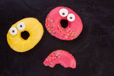 Koyu arka planda iki renkli donut.