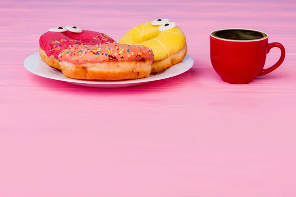 Breakfast with donuts and coffee on wooden table. — Stock Photo, Image