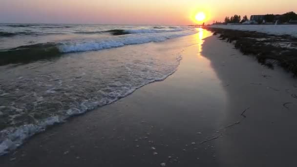 Strand zonsondergang met oranje zon en schuimige golven. — Stockvideo