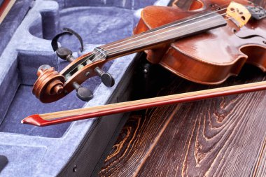 Retro violin on wooden background. clipart