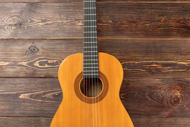 Koyu ahşap zemin üzerine akustik gitar.