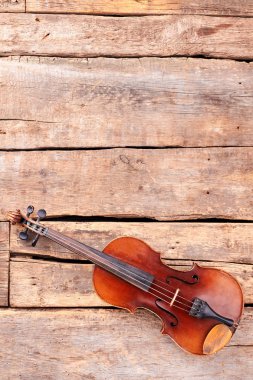 Violin on old wooden planks, top view. clipart
