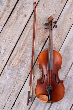 Tahta arka planda keman ve keman sopa.