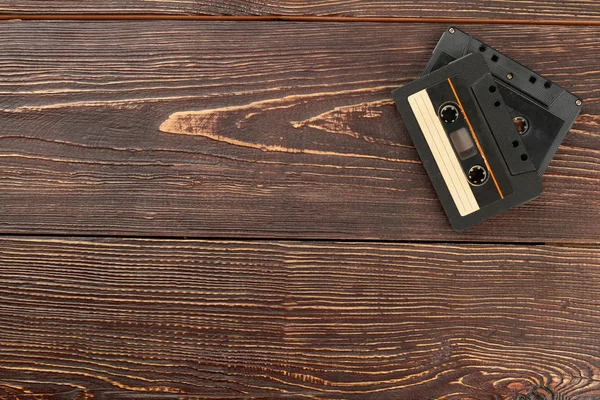 Cassette audio su sfondo marrone in legno . — Foto Stock