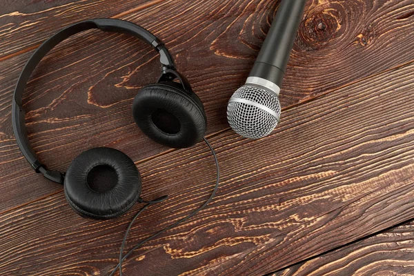 Micrófono y auriculares sobre fondo de madera marrón . —  Fotos de Stock