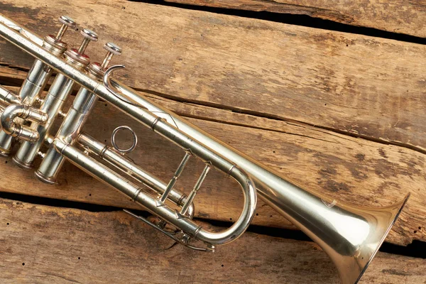 Trumpet on rustic wooden boards.