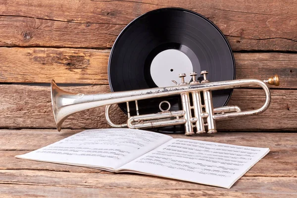 Trumpet och musik papper på gammalt trä. — Stockfoto