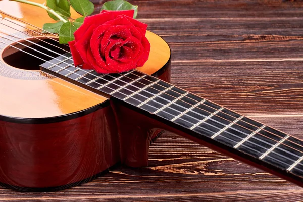 Red rose on acoustic guitar. Royalty Free Stock Images