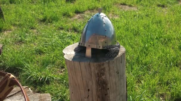 Ancient knights helmet on tree trunk. — Stock Video