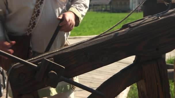 Hombre usando catapulta de madera antigua al aire libre . — Vídeos de Stock