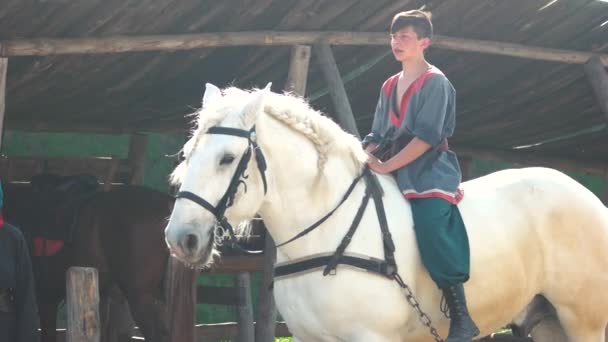 Young cossack duduk di atas kuda putih yang indah . — Stok Video