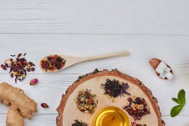 Ahşap arka plan üzerinde bir bardak çay ile çay çeşitleri.