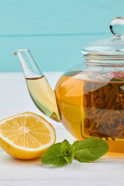 Renk arka planda çaydanlık, limon ve nane.