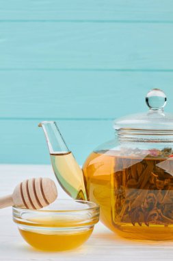 Mavi arka plan üzerinde çaydanlık ve bal ile Kompozisyon.
