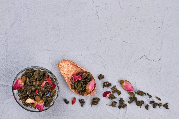 Grüner Tee mit Rosenblüten auf grauem Hintergrund. — Stockfoto