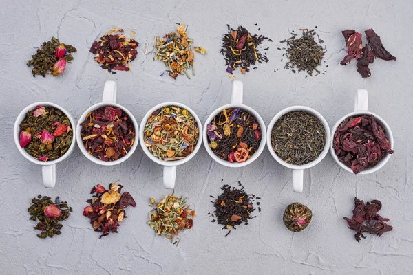 Bowls with different types of dry tea leaves. — Stock Photo, Image