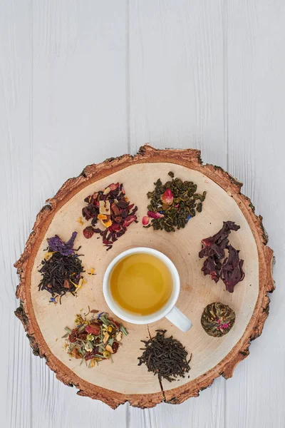 Ağaç dilimi üzerinde bitki çayı ve kuru çay Fincan. — Stok fotoğraf