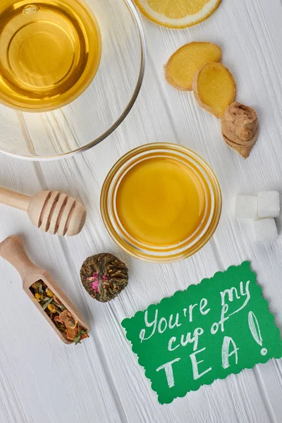 Çay, bal ve ahşap arka plan üzerinde baharat.