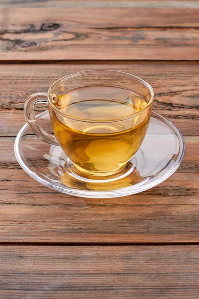 Kahverengi ahşap arka plan üzerinde sıcak çay Fincan.