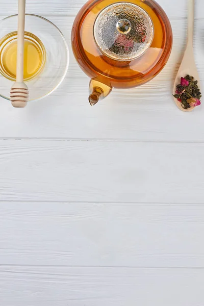 Teapot, spoon with dry tea and honey. — Stock Photo, Image