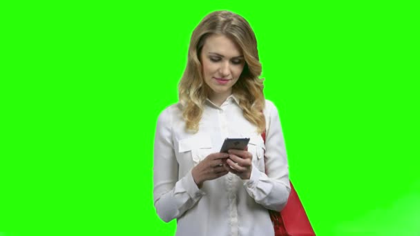 Jeune femme lisant un message texte sur son smartphone. — Video