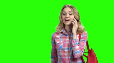 Yeşil ekranda telefon kullanan genç pozitif kadın.