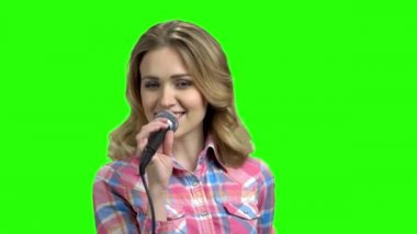 Güzel etkileyici kız mikrofon ile şarkı.