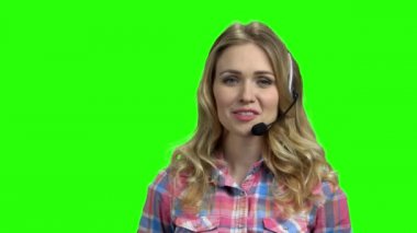 Yeşil ekranda gülümseyen çağrı merkezi operatörü.