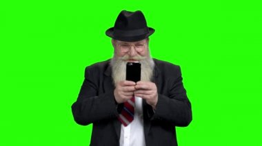 Yaşlı adam cep telefonuyla oyun oynuyor..