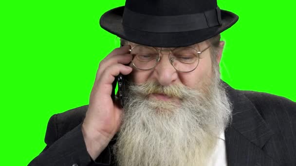 Old bearded man talking on cell phone. — Stock Video