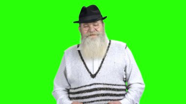 Şapkalı mutlu yaşlı adam başparmağını veriyor.